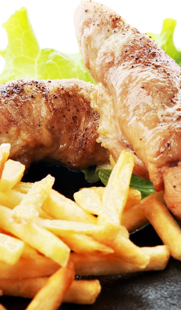 Куриные рулеты с картофелем фри и зелеными листьями салата