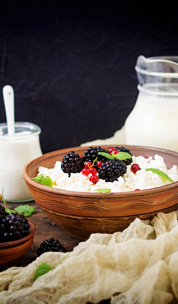 Творог с ягодами и свежим молоком на столе на завтрак