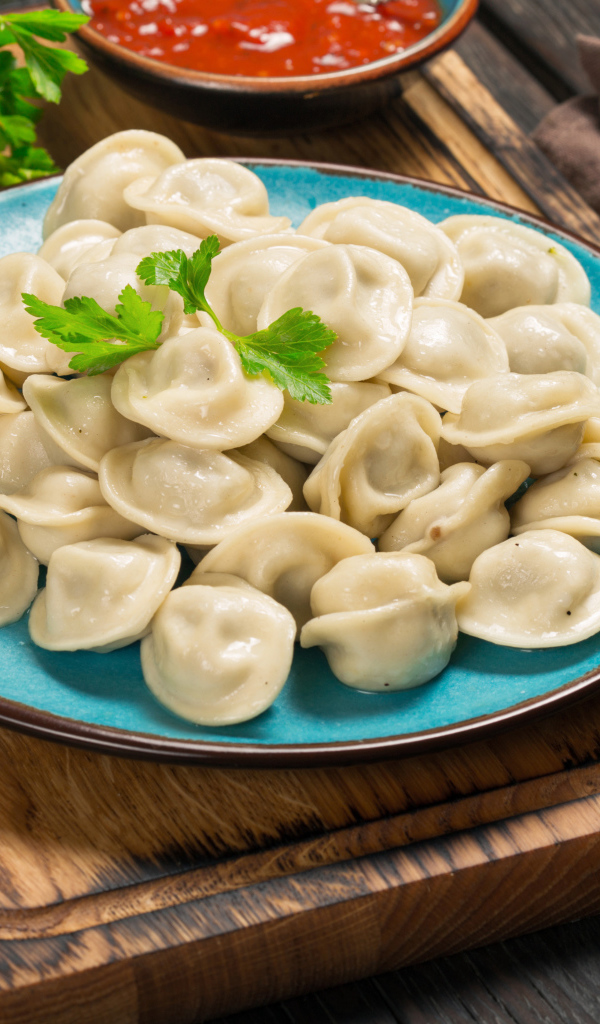 Вкусные пельмени на голубой тарелке 