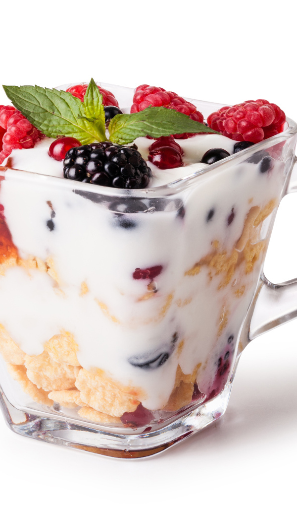 Хлопья с йогуртом и ягодами в стакане на белом фоне