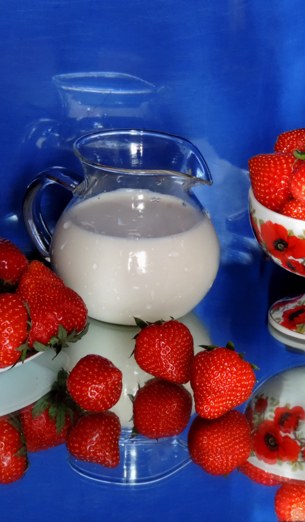 Свежие аппетитные ягоды клубники на столе с молоком