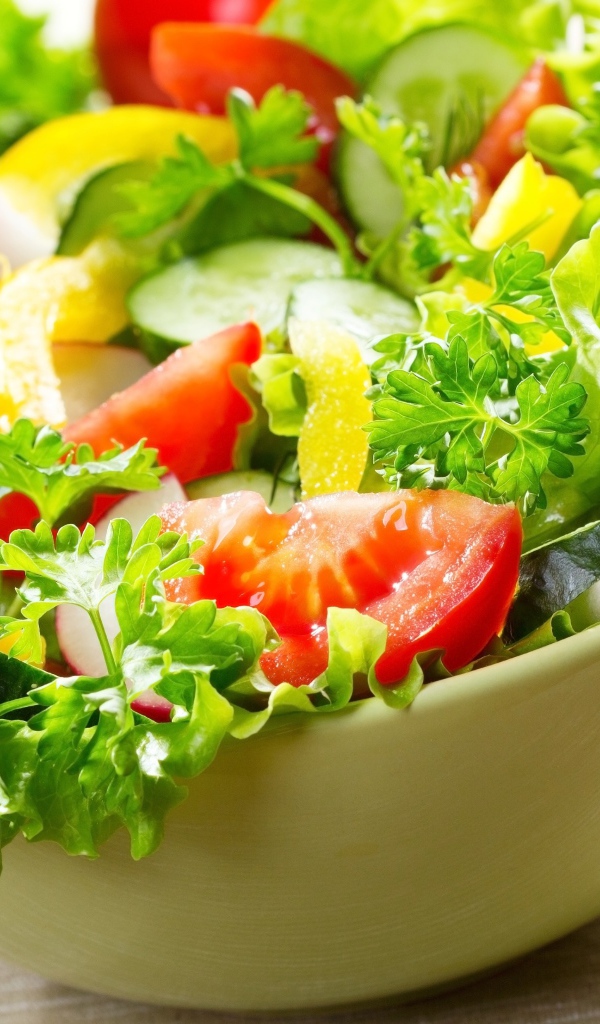 Салат из свежих овощей с зеленью на столе