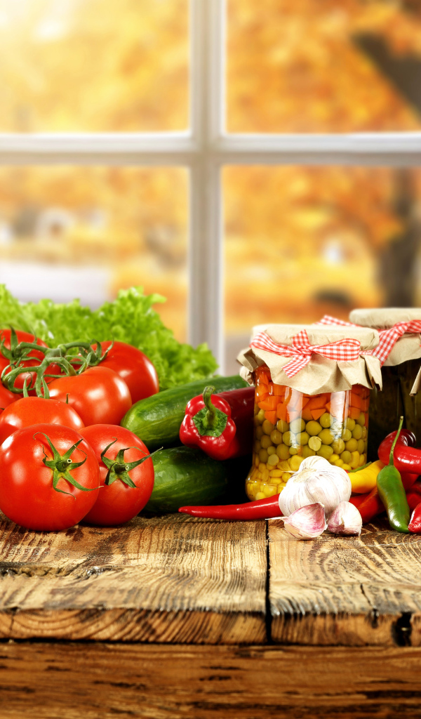 Свежие овощи и зимние заготовки на столе 