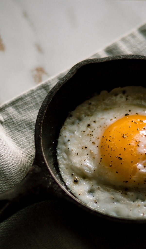 Яичница глазунья на столе в маленькой сковороде