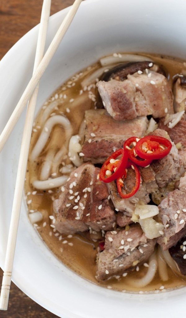 Хайнаньский суп с бараниной, лапшой и кунжутом в белой миске