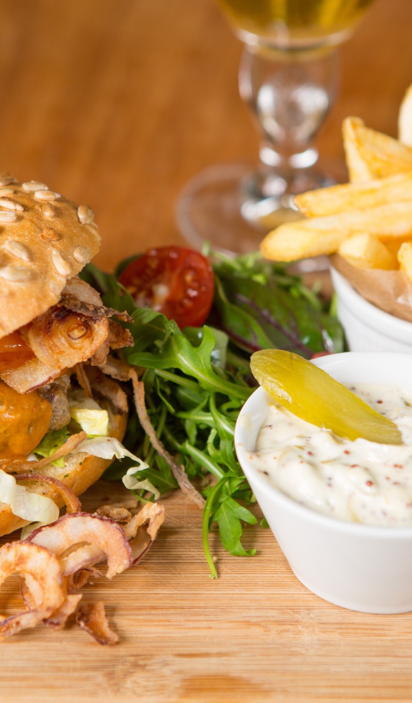 Гамбургер и картошка фри на столе с соусом