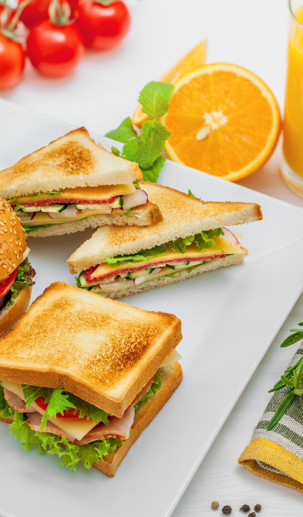 Гамбургер и сендвичи на столе с апельсиновым соком