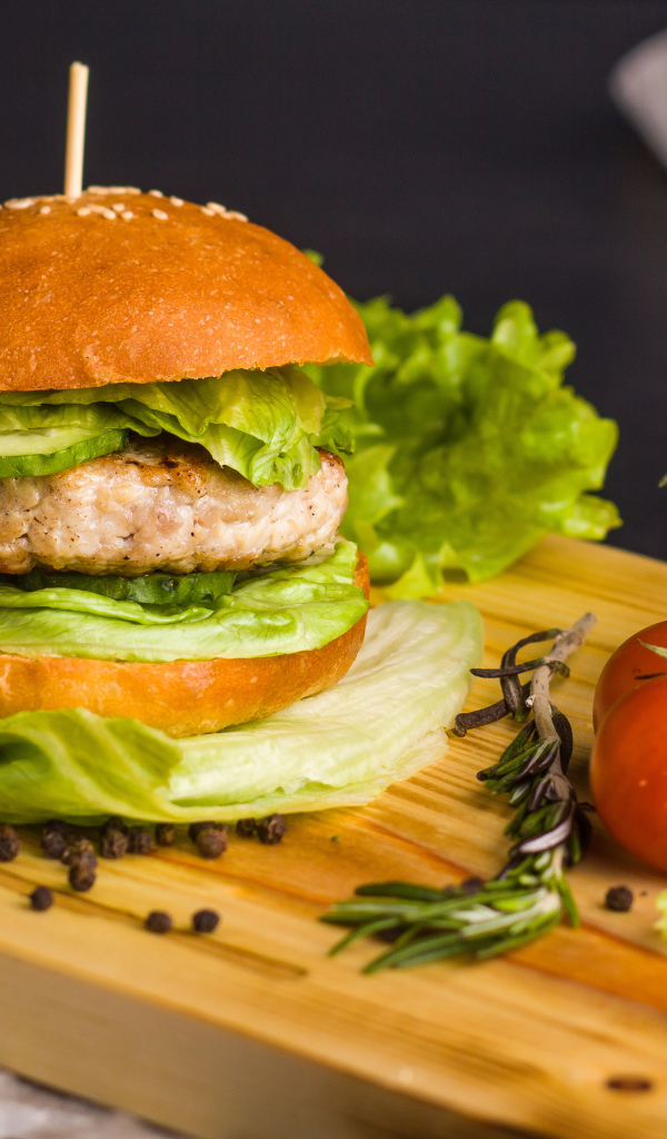 Гамбургер с зеленью на разделочной доске  