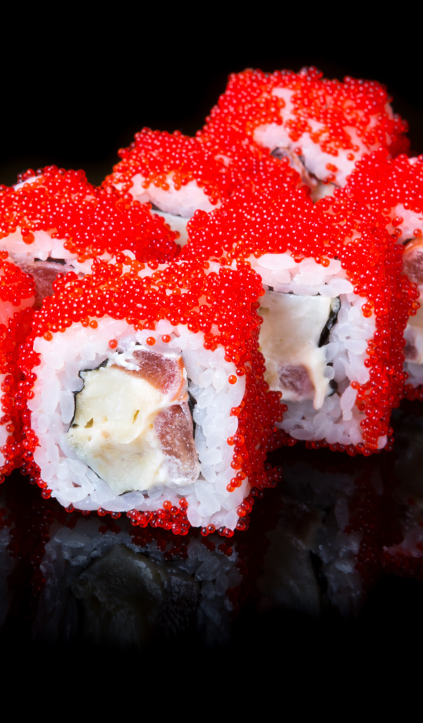 Японские роллы с красной икрой на черном фоне 