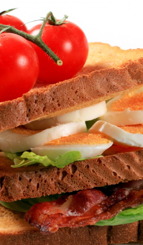 Сэндвич с беконом, яйцами и овощами на белом фоне