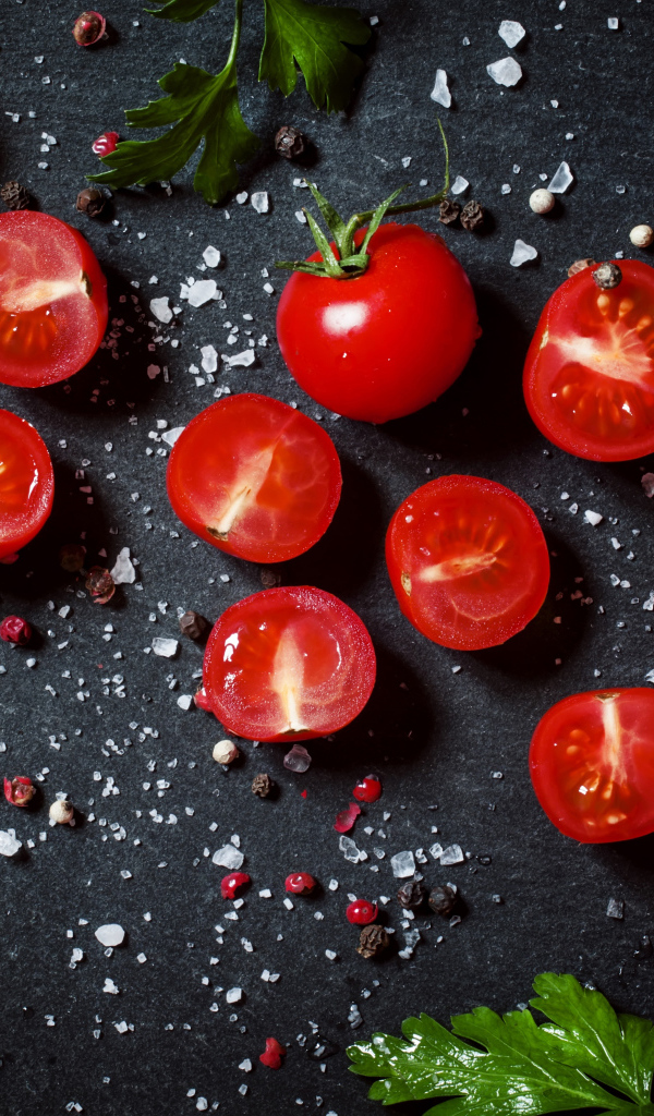 Помидоры на столе с зеленью петрушки и специями