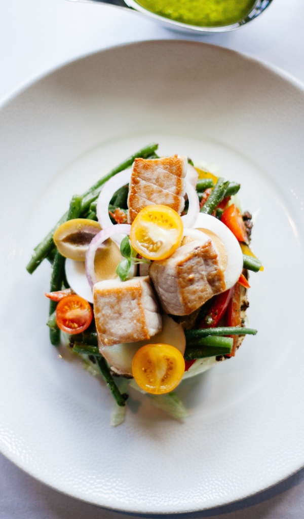 Овощной салат на белой тарелке со столовыми приборами