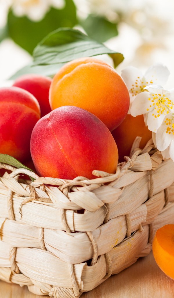 Аппетитные спелые персики в корзине на столе