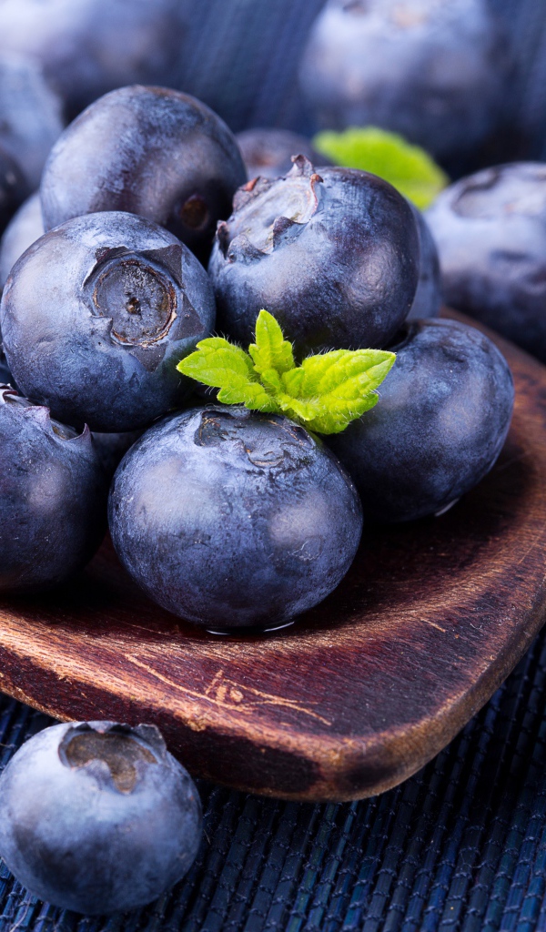 Ягоды спелой черники на деревянной ложке крупным планом