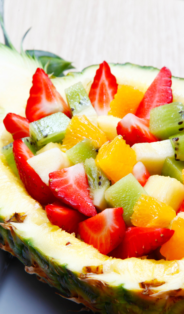 Фруктовый салат из цитрусовых  в тарелке из свежего ананаса 