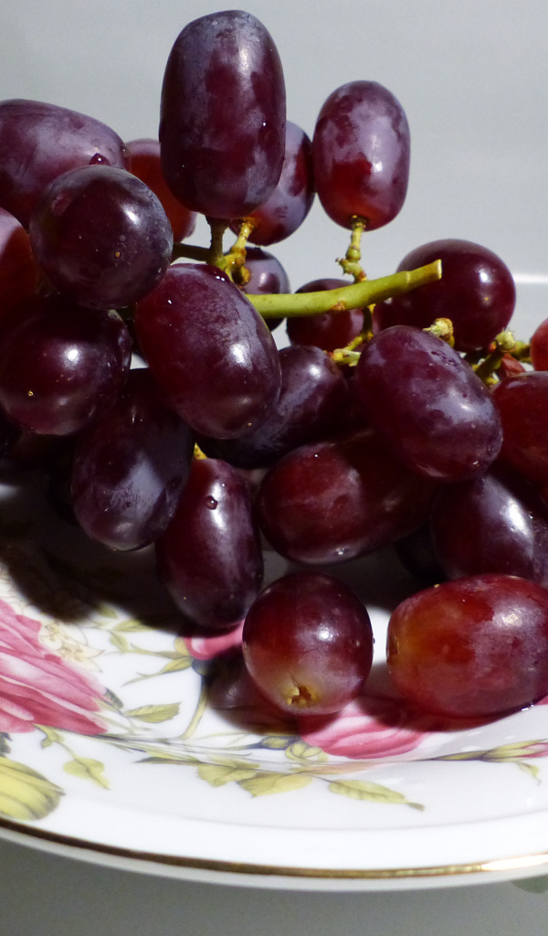 Розовый виноград на тарелке крупным планом