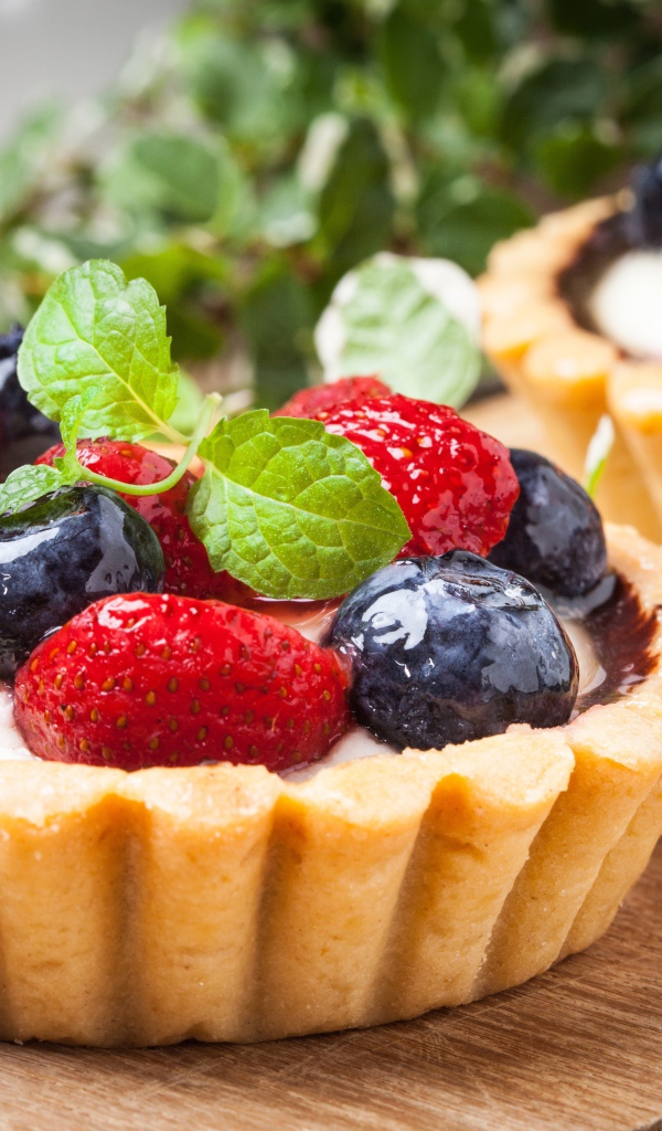 Пирожное с кремом и свежими ягодами черники и клубники