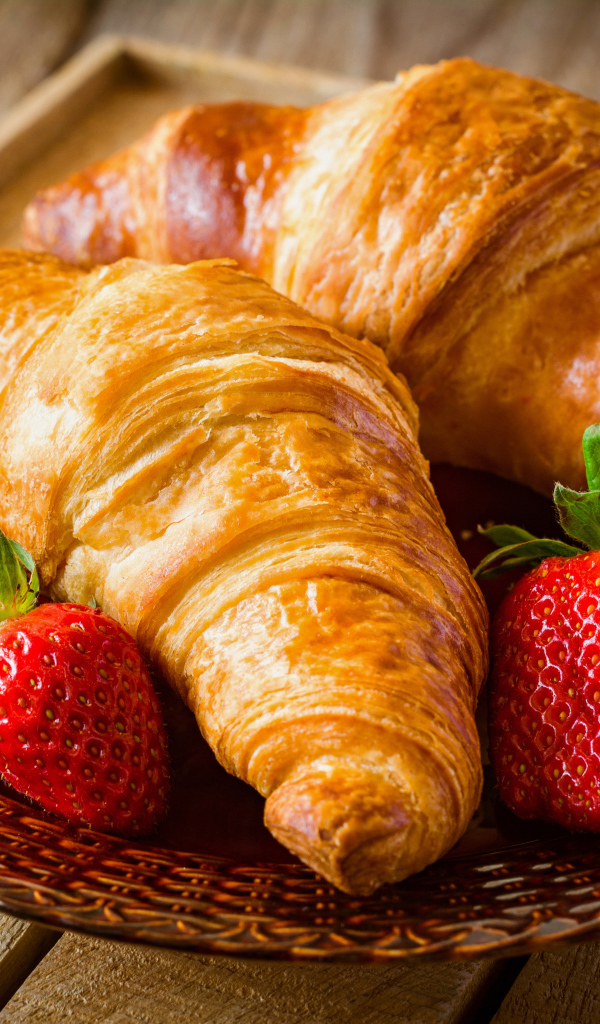 Два свежих круассана со свежей клубникой