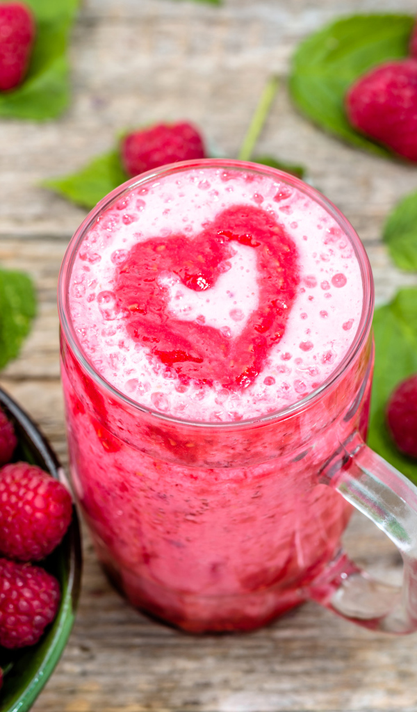 Бокал малинового коктейля со свежими ягодами малины