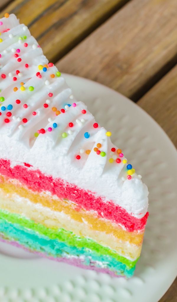 Кусок разноцветного торта на белой тарелке