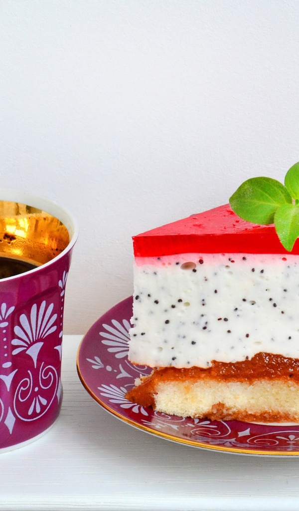 Кусок пирожного на тарелке с чашкой чая