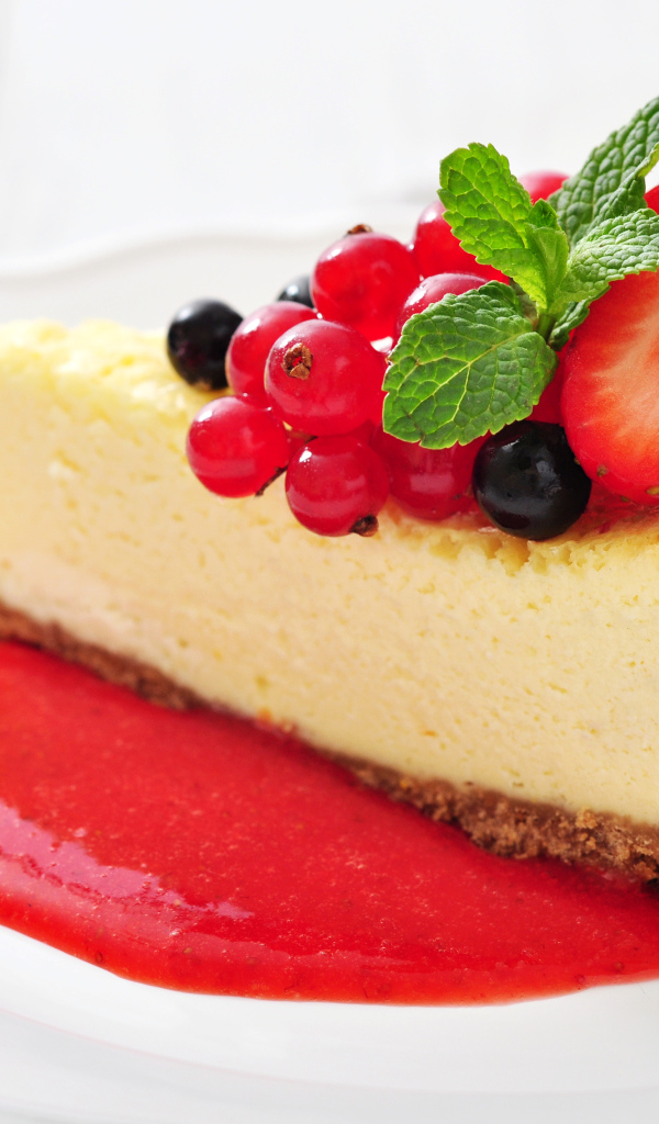 Кусок чизкейка с джемом и ягодами смородины и клубники