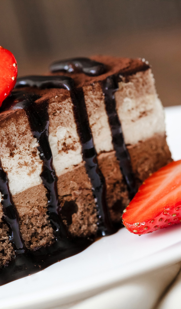 Кусок шоколадного пирожного со свежей клубникой