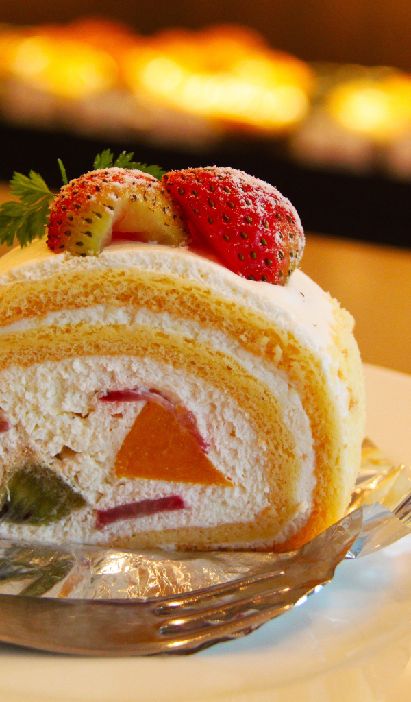 Кусок сладкого бисквитного рулета с клубникой 