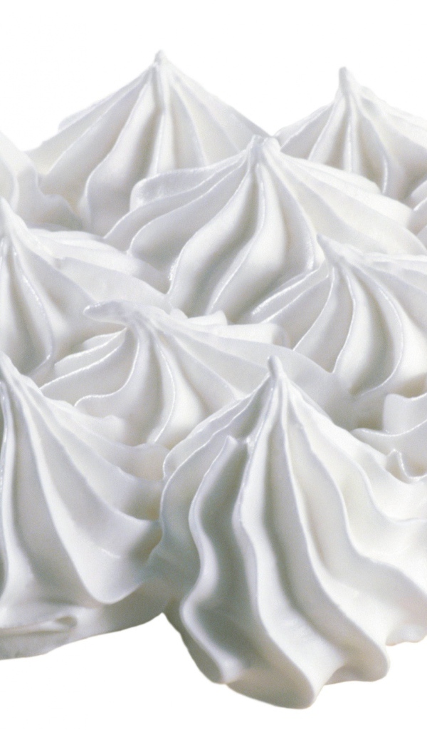 Воздушные взбитые сливки на белом фоне