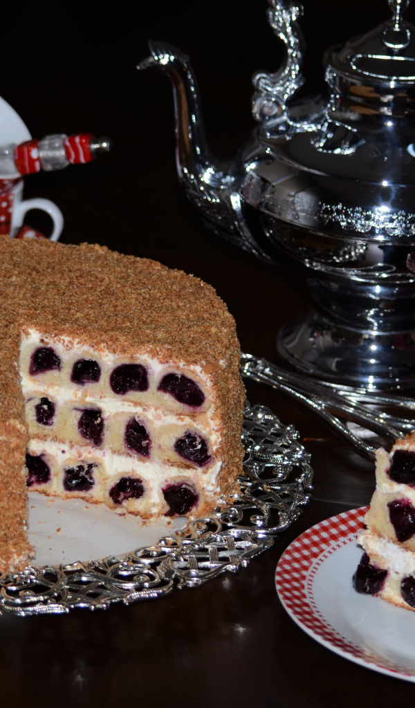 Аппетитный торт с вишней и чай на столе на черном фоне