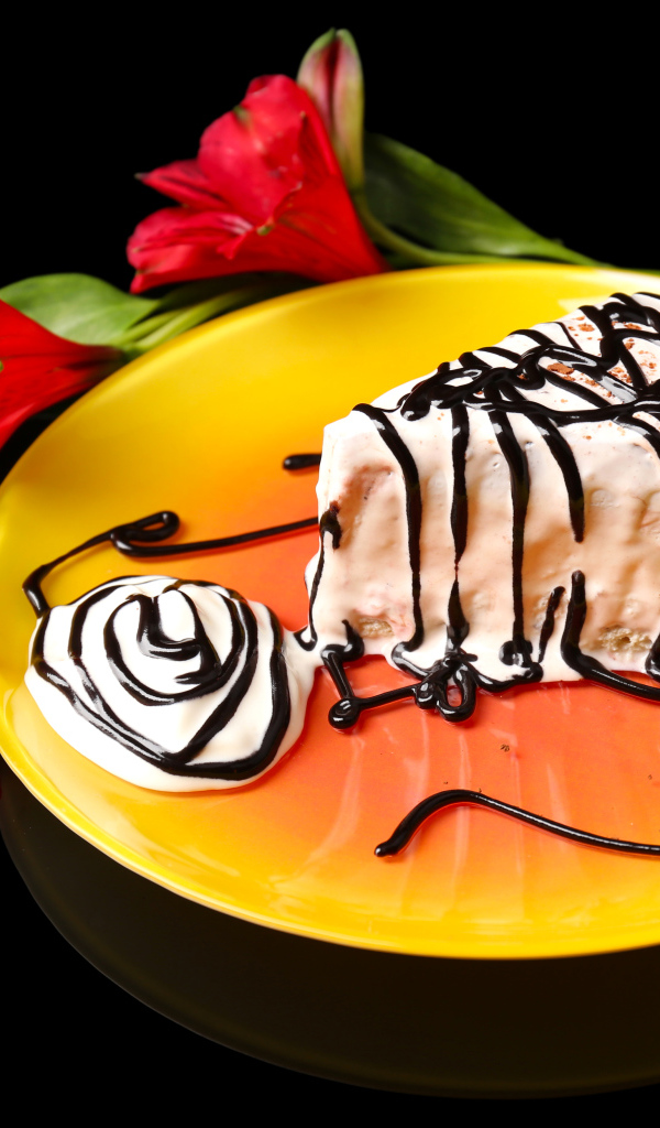 Аппетитное пирожное с шоколадом и цветком альстремерия на черном фоне