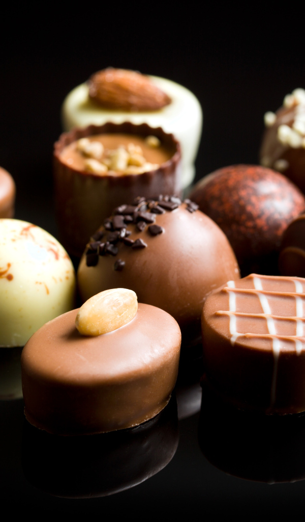 Аппетитные шоколадные конфеты на черном фоне