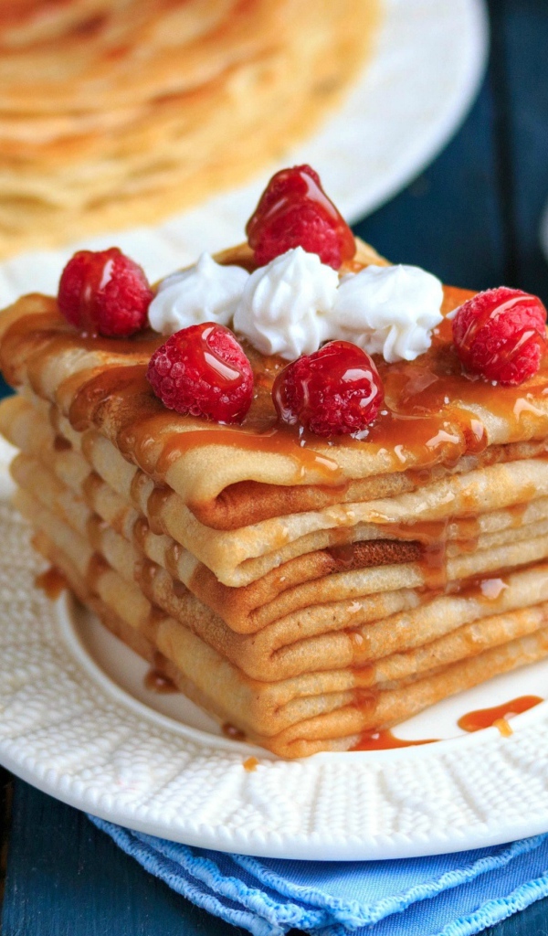 Аппетитные тонкие блинчики с ягодами малины и сиропом