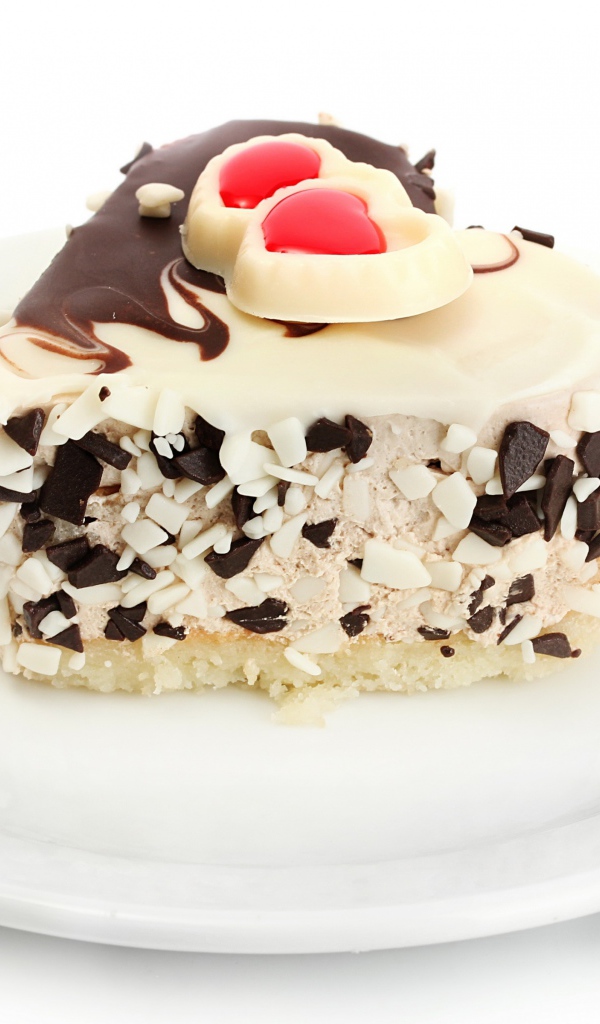 Аппетитное пирожное в форме сердца с шоколадом на белой тарелке