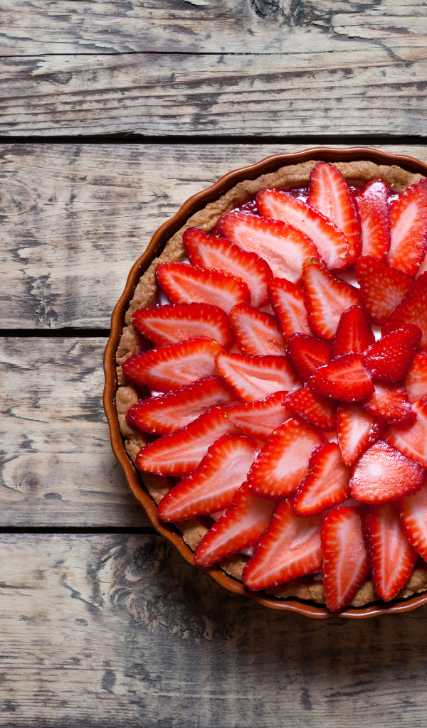 Аппетитный пирог со свежей клубникой на столе 