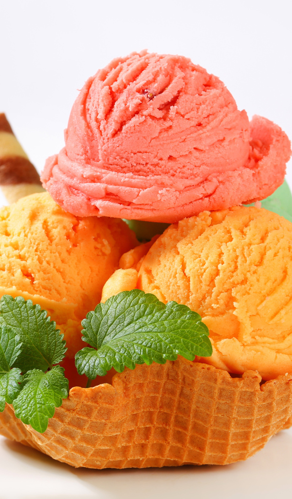 Шарики персикового и малинового мороженого в вафельной корзинке