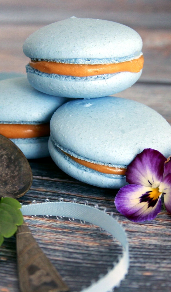 Голубые макаруны на столе с цветком 