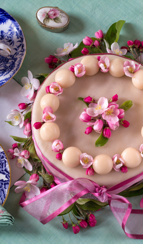 Торт с розовыми цветами на столе с красивым сервизом 