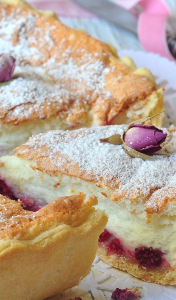 Пирог с суфле и малиной посыпанный сахарной пудрой и цветами