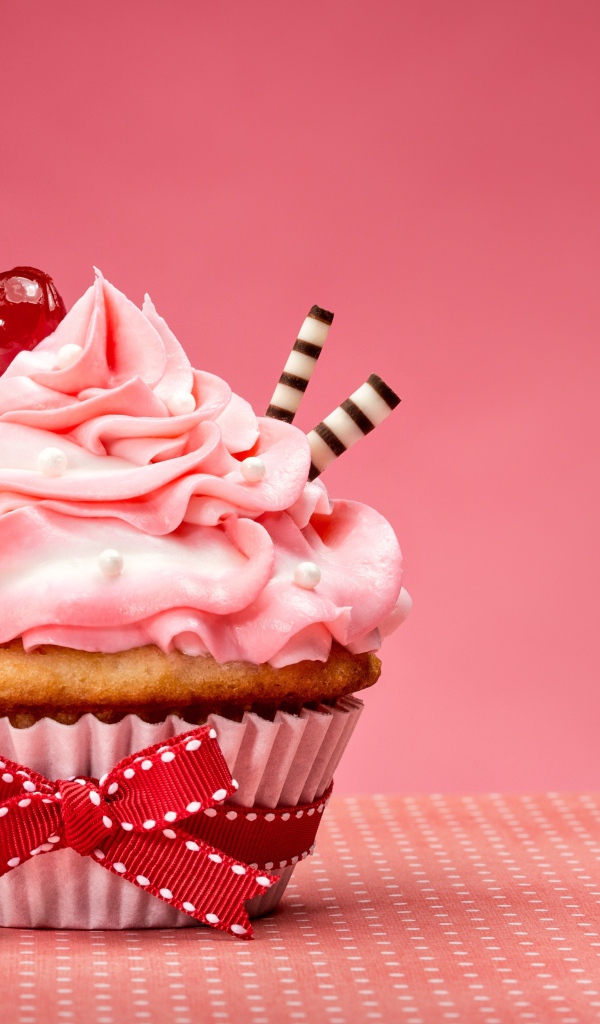 Капкейк с кремом и вишней красиво украшен лентой