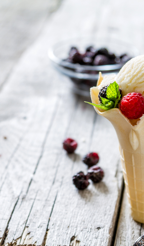 Сливочное мороженое в вафельном стаканчике с ягодами