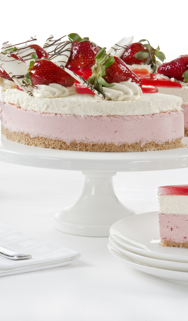 Вкусный торт с суфле, белым шоколадом и ягодами клубники на белом фоне