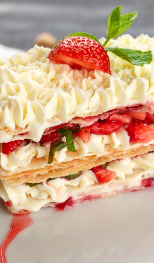Вкусное сладкое пирожное с кремом и клубникой