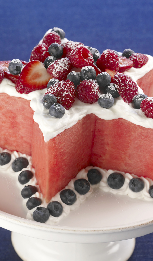 Десерт из арбуза со сливками и ягодами малины, клубники и черники