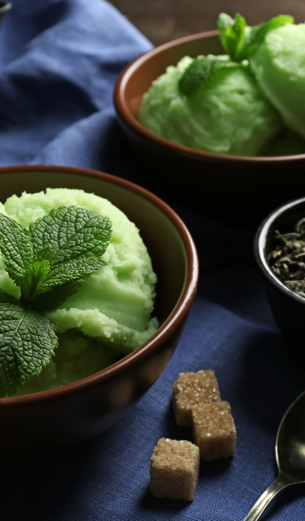 Зеленое мятное мороженое и кусочки сахара на столе 
