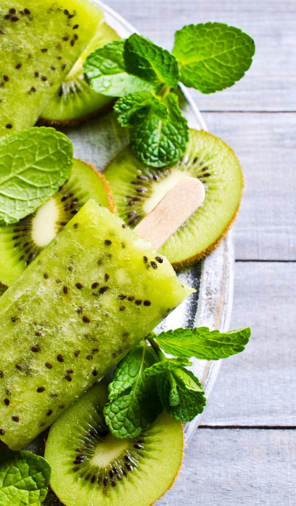 Мороженое с киви и листиками мяты на деревянном столе