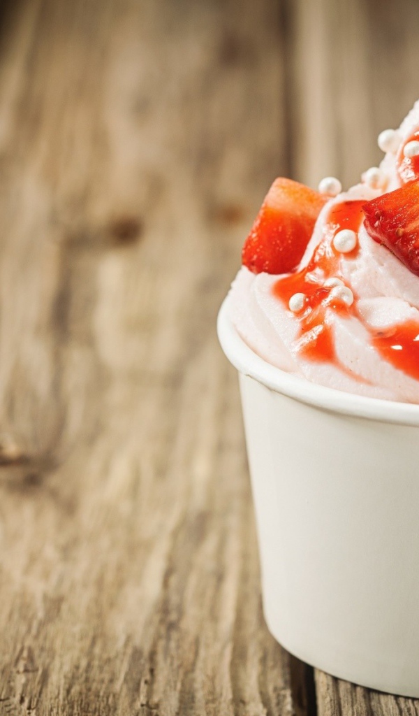Мороженое с клубникой в белом стакане 
