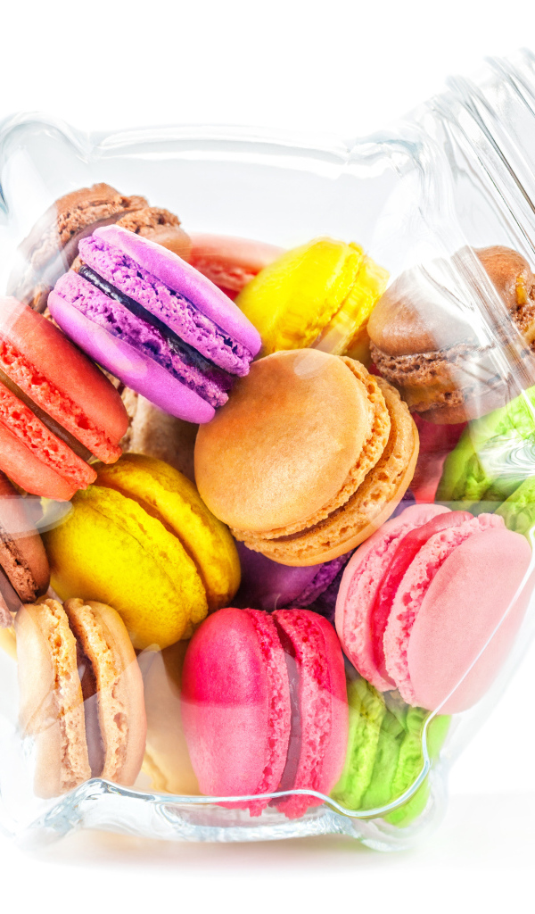 Разноцветные макаруны в стеклянной банке на белом фоне