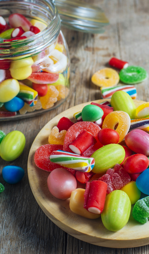 Разноцветные мармеладные конфеты в стеклянной банке на столе