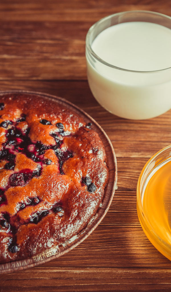 Пирог с ягодами, медом и молоком на столе